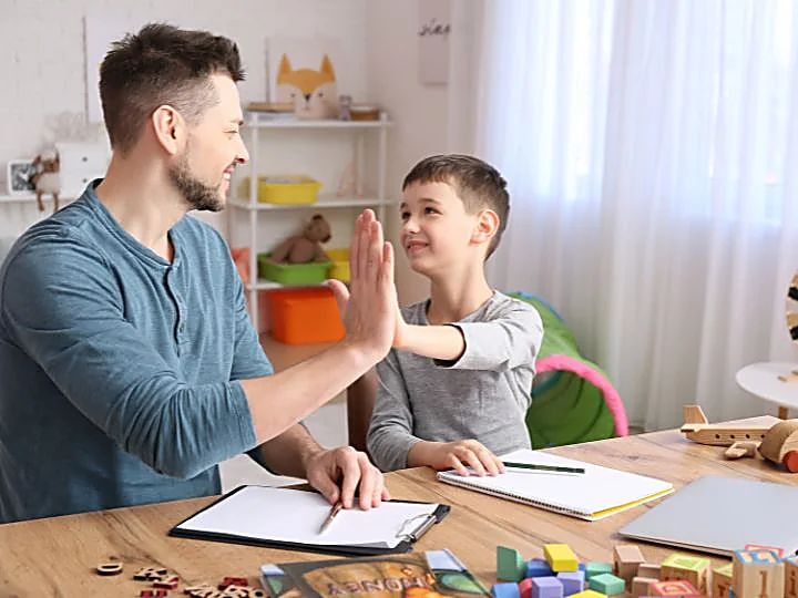 Educatore e bambino si danno il cinque durante un incontro